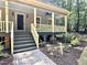 Inviting covered front porch with painted railing and brick paver walkway at 8116 Reynard Rd, Chapel Hill, NC 27516
