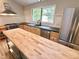 Well-lit kitchen with stainless appliances, butcher block island, and ample counter space at 8116 Reynard Rd, Chapel Hill, NC 27516