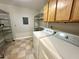 Functional laundry room equipped with a washer, dryer, and shelving at 8116 Reynard Rd, Chapel Hill, NC 27516