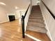 Open floor plan with hardwood floors, staircase, and a fireplace at 8116 Reynard Rd, Chapel Hill, NC 27516