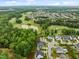 Expansive aerial view showcasing the community, golf course, and scenic pond at 821 Rambling Oaks Ln, Holly Springs, NC 27540
