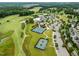 An aerial view showcases a community with a golf course, tennis courts, pool, and clubhouse at 821 Rambling Oaks Ln, Holly Springs, NC 27540