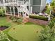 Aerial view of backyard putting green with beautiful greenery, landscape, and outdoor seating area at 821 Rambling Oaks Ln, Holly Springs, NC 27540
