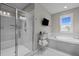 This bathroom features a glass shower and a soaking tub with a mounted tv at 821 Rambling Oaks Ln, Holly Springs, NC 27540