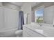 Bright bathroom featuring a tub with shower, white tiling, and a large mirror at 821 Rambling Oaks Ln, Holly Springs, NC 27540