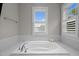 Bright bathroom features a soaking tub with natural light from two windows at 821 Rambling Oaks Ln, Holly Springs, NC 27540