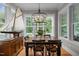 Elegant dining room featuring a large window, wood table, and decorative sailboat at 821 Rambling Oaks Ln, Holly Springs, NC 27540