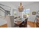 Dining room featuring natural light from shuttered windows, decorative chandelier, and staircase access at 821 Rambling Oaks Ln, Holly Springs, NC 27540