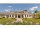 Stunning white clubhouse with meticulous landscaping, purple flowers and covered entry at 821 Rambling Oaks Ln, Holly Springs, NC 27540