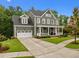 Charming two-story home with a spacious driveway, lush lawn, green siding, and covered porch at 821 Rambling Oaks Ln, Holly Springs, NC 27540