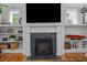 Close up of fireplace with built-in shelves, shiplap, and hardwood floors at 821 Rambling Oaks Ln, Holly Springs, NC 27540