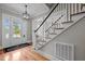 Inviting foyer with hardwood floors, decorative rug, and staircase with black iron railing and white posts at 821 Rambling Oaks Ln, Holly Springs, NC 27540