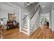 Elegant foyer with hardwood floors, white staircase, chandelier, and views into the dining room at 821 Rambling Oaks Ln, Holly Springs, NC 27540