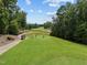 Scenic golf course view with players, a lush green fairway, and a golf cart on a sunny day at 821 Rambling Oaks Ln, Holly Springs, NC 27540
