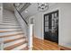 Hallway featuring a staircase with wood treads and black iron railing, and glass paneled doors at 821 Rambling Oaks Ln, Holly Springs, NC 27540