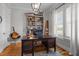 Bright home office with built-in shelves, wooden desk, and natural light from a window at 821 Rambling Oaks Ln, Holly Springs, NC 27540