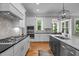 Spacious kitchen featuring stainless steel appliances, white cabinetry, and a gray island with marble countertop at 821 Rambling Oaks Ln, Holly Springs, NC 27540