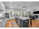 Open-concept kitchen with an island, stainless appliances, and easy access to the living room at 821 Rambling Oaks Ln, Holly Springs, NC 27540
