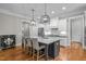 Spacious kitchen with a center island, white cabinets, modern fixtures, and hardwood flooring at 821 Rambling Oaks Ln, Holly Springs, NC 27540