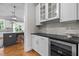 Modern kitchen with white cabinetry, wine cooler, granite countertops, and view into breakfast nook at 821 Rambling Oaks Ln, Holly Springs, NC 27540