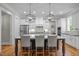 Bright kitchen featuring white cabinets, stainless steel appliances, and a large island with bar seating at 821 Rambling Oaks Ln, Holly Springs, NC 27540