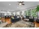 Open-concept living room with hardwood floors, large windows, and a view into the kitchen at 821 Rambling Oaks Ln, Holly Springs, NC 27540