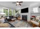 Cozy living room with a fireplace, built-in shelving, hardwood floors, and lots of natural light at 821 Rambling Oaks Ln, Holly Springs, NC 27540