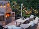 Cozy brick outdoor fireplace with seating and string lights create a warm ambiance at 821 Rambling Oaks Ln, Holly Springs, NC 27540