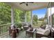 Covered porch with comfortable seating, a ceiling fan, and serene views of lush landscaping at 821 Rambling Oaks Ln, Holly Springs, NC 27540