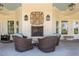 Cozy porch with brick fireplace, wicker seating and view of lush greenery at 821 Rambling Oaks Ln, Holly Springs, NC 27540