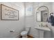 Charming powder room with pedestal sink, decorative mirror, and stylish fixtures at 821 Rambling Oaks Ln, Holly Springs, NC 27540