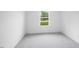 This bedroom offers a serene space with soft gray carpeting, bright white walls, and a window with a view of lush greenery at 8763 Wardle Ct, Wake Forest, NC 27587
