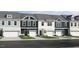 View of newly constructed townhomes featuring a mix of colors and single-car garages at 8763 Wardle Ct, Wake Forest, NC 27587