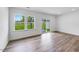 Bright and airy living room featuring hardwood floors, large windows and glass sliding doors at 8763 Wardle Ct, Wake Forest, NC 27587