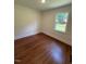 Bright bedroom featuring a window and beautiful hardwood flooring, perfect for relaxation at 902 Roanoke Ave, Henderson, NC 27536