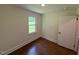 Neutral bedroom with hardwood flooring, window and white door at 902 Roanoke Ave, Henderson, NC 27536