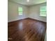 Bedroom featuring hardwood floors and natural light from the two windows at 902 Roanoke Ave, Henderson, NC 27536