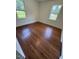 A bright bedroom with hardwood floors and two windows at 902 Roanoke Ave, Henderson, NC 27536