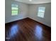 Hardwood floors and a large window add charm to this bedroom at 902 Roanoke Ave, Henderson, NC 27536