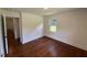 Bright bedroom with beautiful hardwood floors and a doorway into another room at 902 Roanoke Ave, Henderson, NC 27536