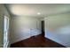 A bright bedroom with hardwood floors, a window, and white walls at 902 Roanoke Ave, Henderson, NC 27536