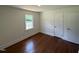 A bright bedroom with hardwood floors, a window, and white walls at 902 Roanoke Ave, Henderson, NC 27536