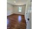 Empty bedroom featuring hardwood floors and a double-door closet at 902 Roanoke Ave, Henderson, NC 27536