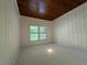 A bedroom with hardwood floors and white paneled walls with a view at 902 Roanoke Ave, Henderson, NC 27536