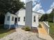 Rear exterior featuring newly stained deck, fresh exterior paint and chimney at 902 Roanoke Ave, Henderson, NC 27536