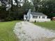 Desirable home showcasing fresh gravel driveway and well-maintained landscaping at 902 Roanoke Ave, Henderson, NC 27536