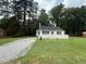 Quaint single-story home featuring a welcoming white deck and a long gravel driveway at 902 Roanoke Ave, Henderson, NC 27536