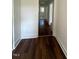 Hallway featuring hardwood floors, neutral walls, and white trim at 902 Roanoke Ave, Henderson, NC 27536