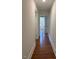 Hallway with hardwood floors, white walls, and access to other rooms at 902 Roanoke Ave, Henderson, NC 27536