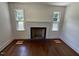 Bright living room featuring a classic fireplace and hardwood flooring at 902 Roanoke Ave, Henderson, NC 27536